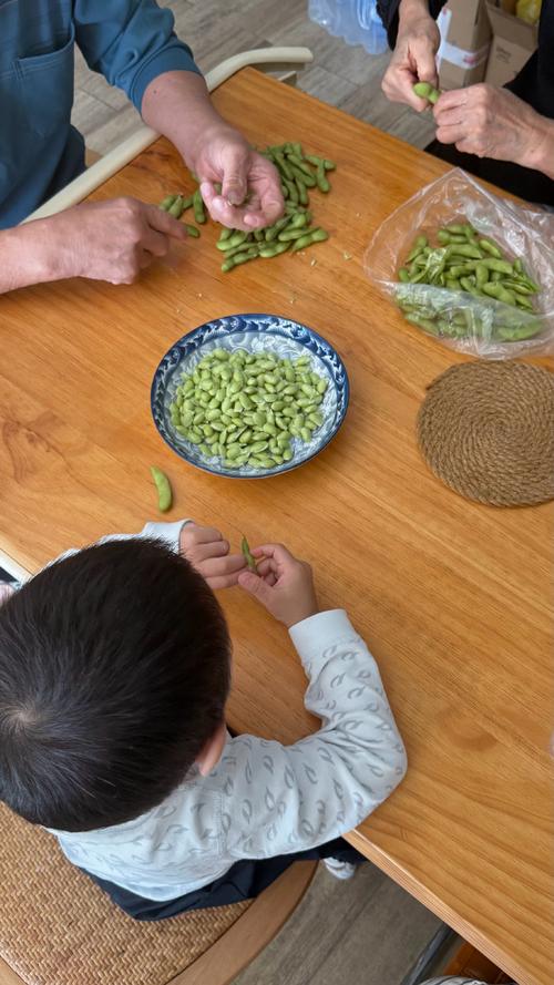 老人与孩子在家剥毛豆场景实物图