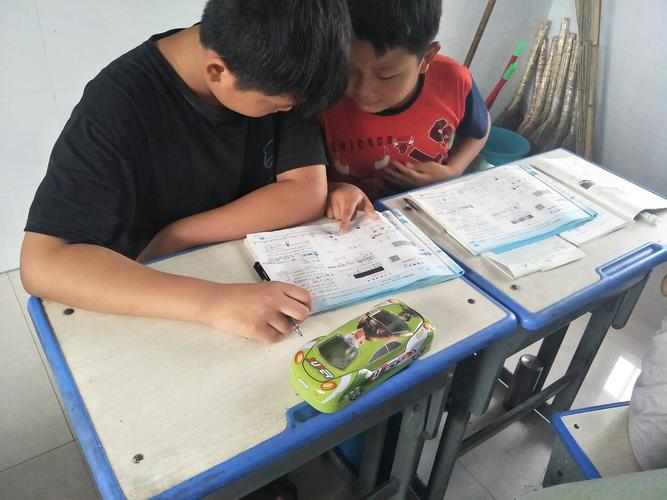 小学教室两个孩子对着旧作业本找证据
