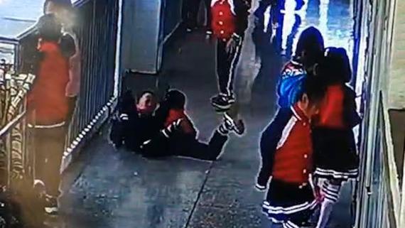 小学走廊上被同学撞掉书本的小学生愣在原地的真实场景