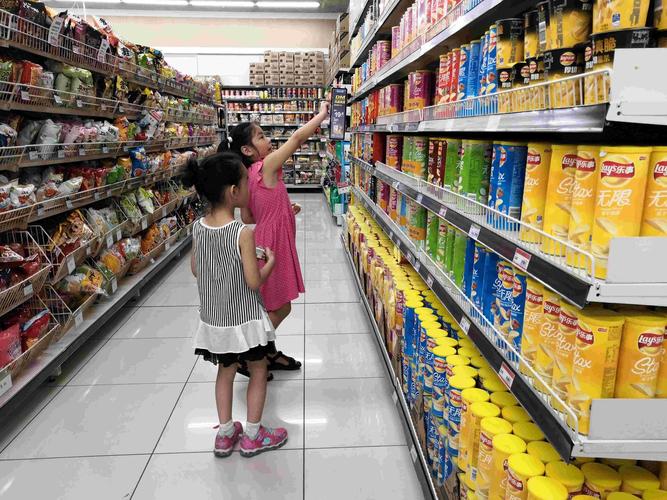 家长和孩子在超市货架前用便签对比零食包装示意图