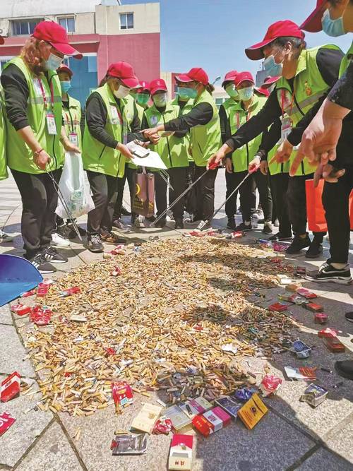 居民小区单元楼垃圾桶旁捡拾他人丢弃的烟蒂的日常场景