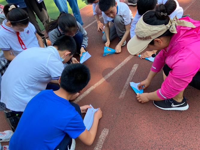 小学操场阳光体育课上学生递的皱巴巴硬沙纸板