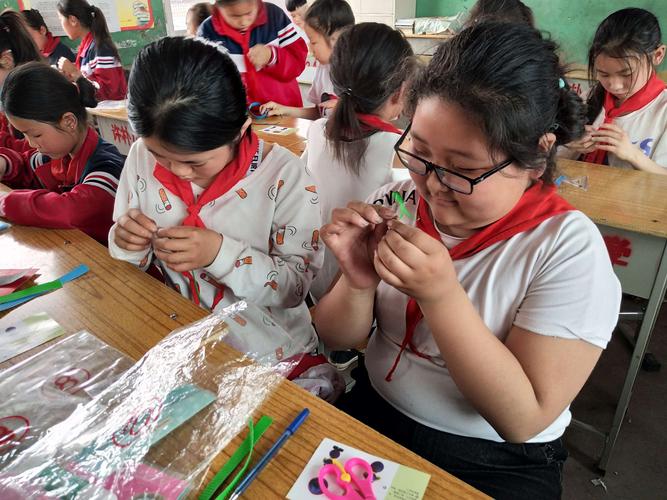 小学课堂同桌友善互助完成手工制作场景