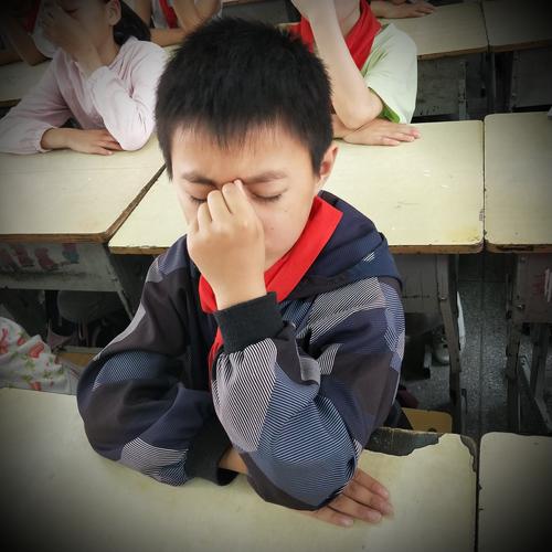 小学教室墙角躲着哭的男生