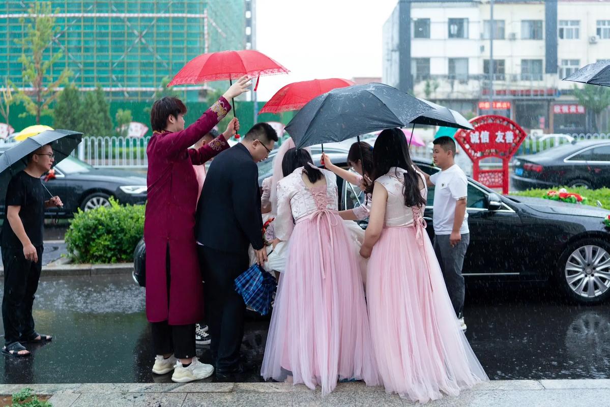 雨中伴娘团用外套护住新娘婚纱