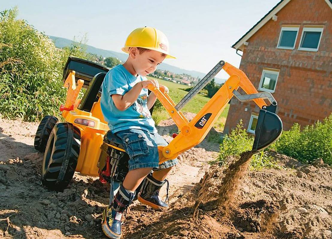 孩子手指着窗外建筑工地的起重机