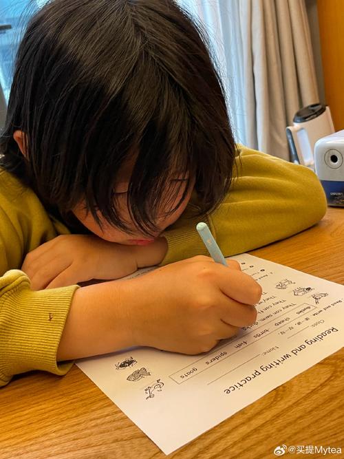 小学孩子写英文作文咬笔发呆场景