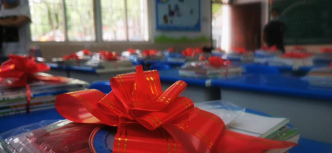 小学教室角落放着散落红绳中国结的木质铅笔盒