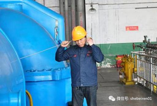 工人使用听棒检查大型旋转设备状况