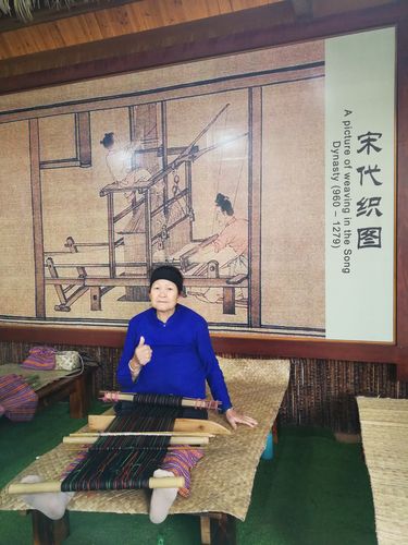 什保村王春妹坐在踞腰织机前织大力神纹筒裙