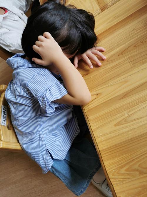图书馆里小男孩被妈妈拽着手委屈低头的细节