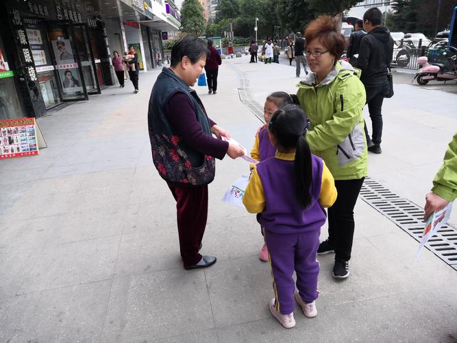 妈妈蹲在小区路边指着商铺招牌和孩子认字