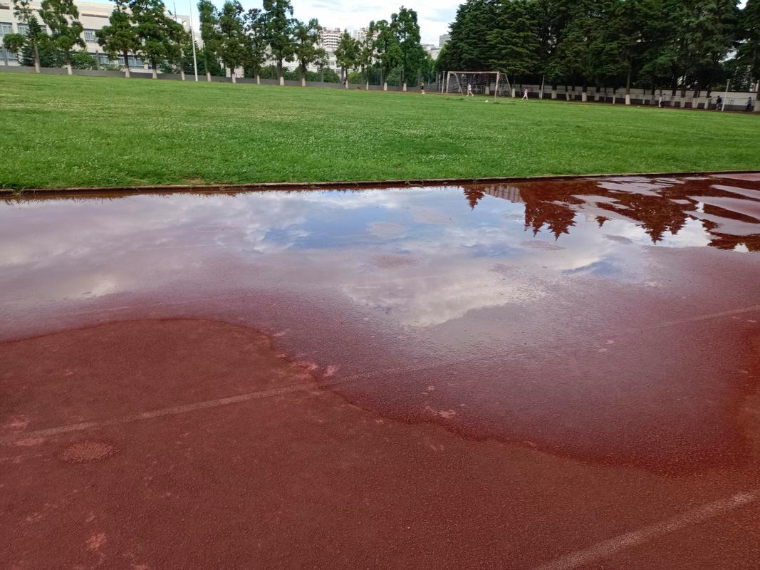 空无一人的操场跑道雨后积水倒映天空