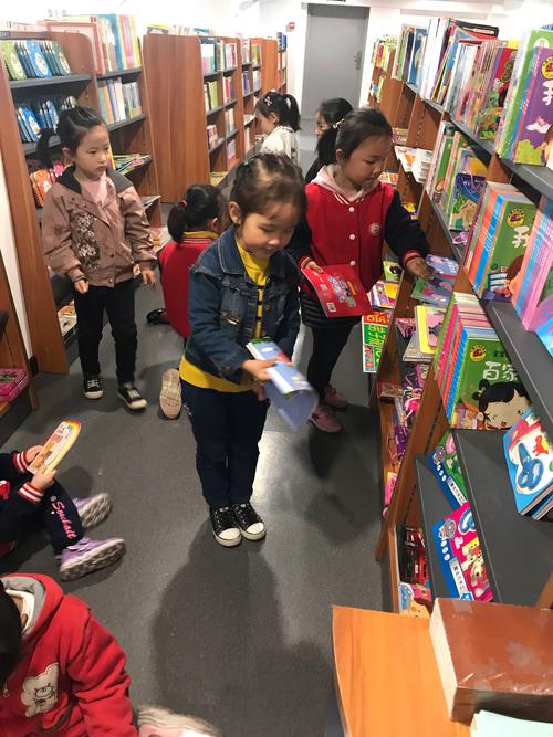 实体书店儿童区小女孩蹲坐画画场景