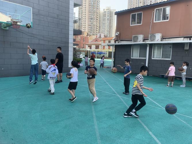 工业厂区家长陪孩子户外打球活动场景