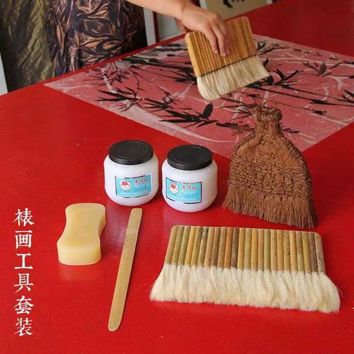 裱画师用棕刷给宣纸背面刷浆糊的特写