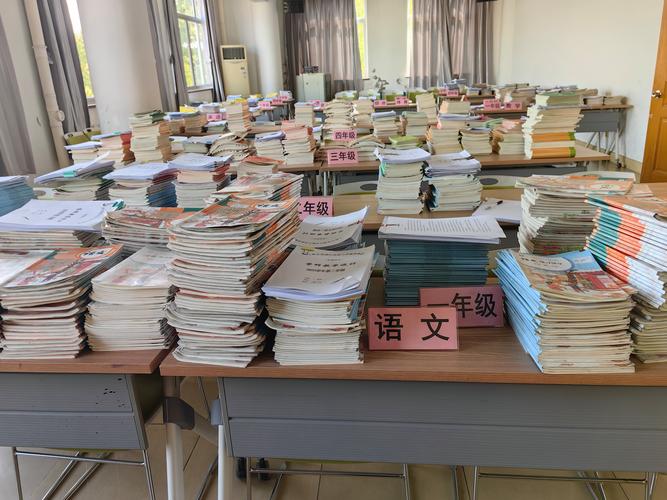 小学教室讲台上堆积的待改语文作业本