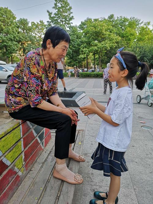 小学门口奶奶追着给放学孙子递保温杯的日常场景