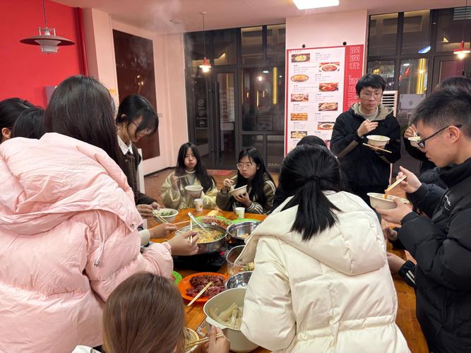 大学食堂里学生干部和同班同学围坐吃火锅