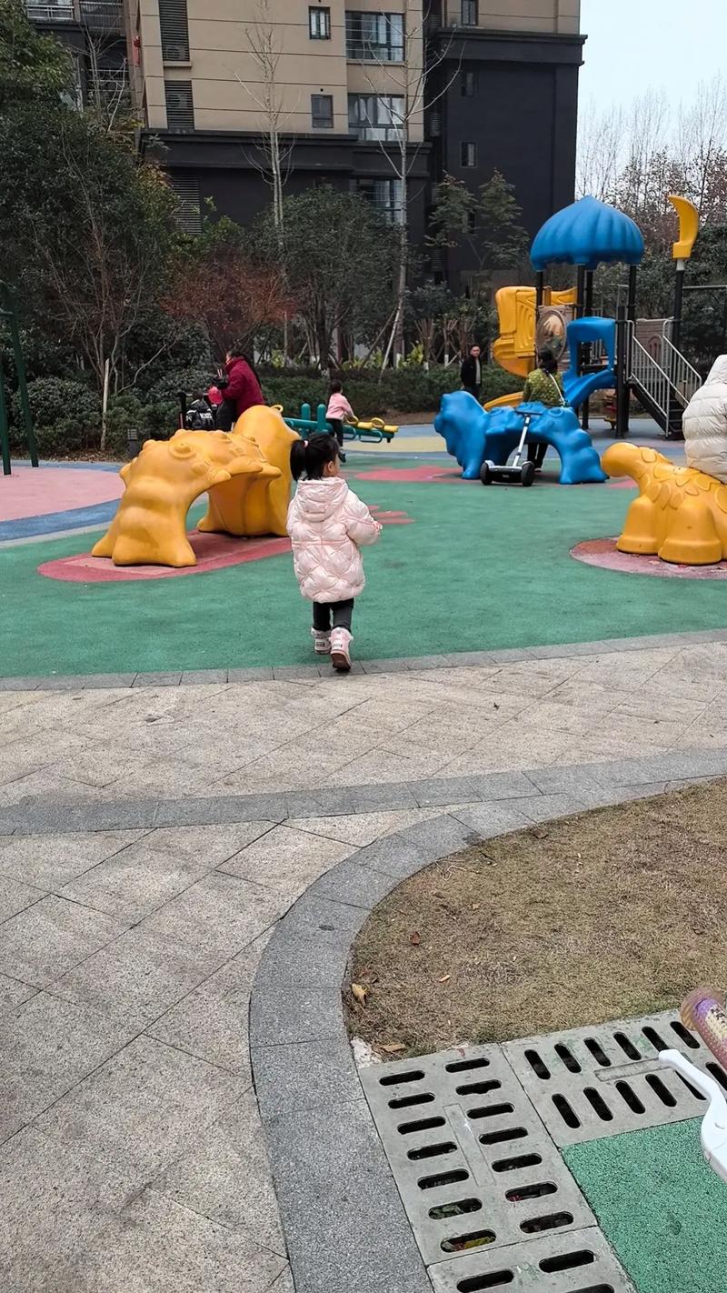 小区儿童滑梯入口站着不敢下滑的小女孩