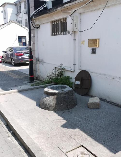 苏州小巷里居民仍在使用的活水古井,井边有人洗菜