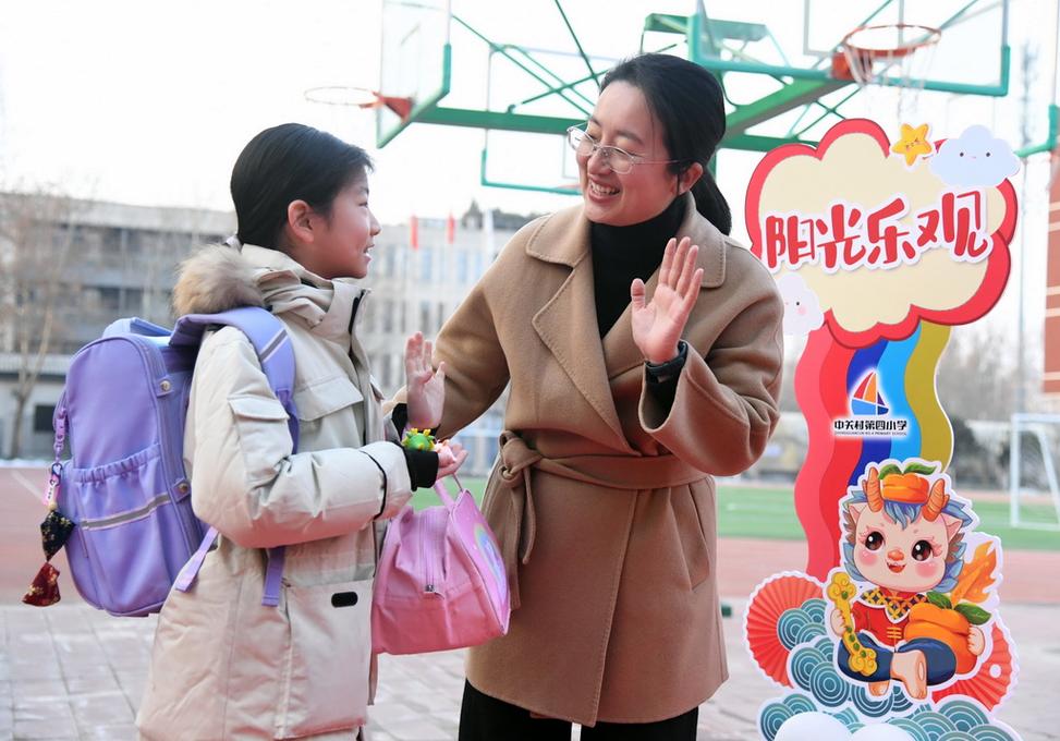 校长在校门口与小学生击掌问好的温馨场景