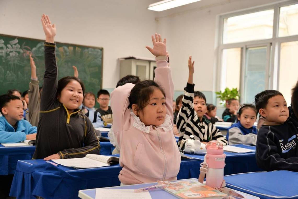 中学语文课堂学生举手发言场景