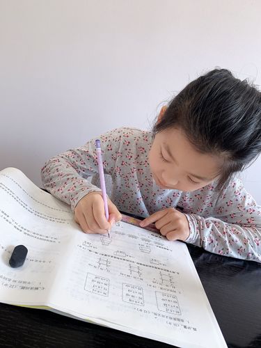 小学生趴在书桌前抄错题皱着眉的真实居家场景