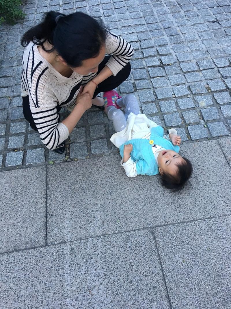 宝妈蹲在地上安抚因为流程被打乱哭闹的幼儿实景图