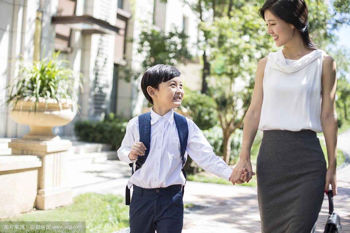 妈妈接孩子放学时和孩子笑着说话的日常场景